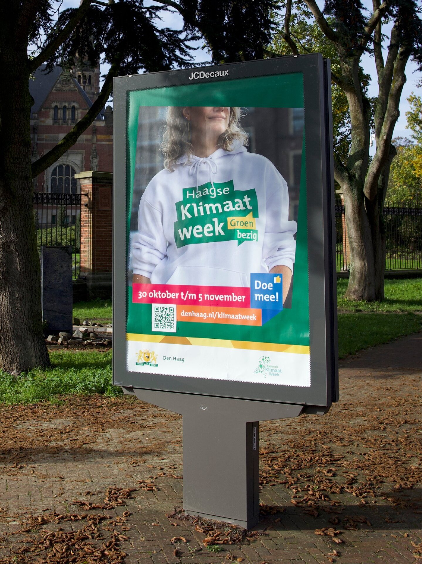 campagne cityboard met vrouw met trui met logo haagse klimaatweek